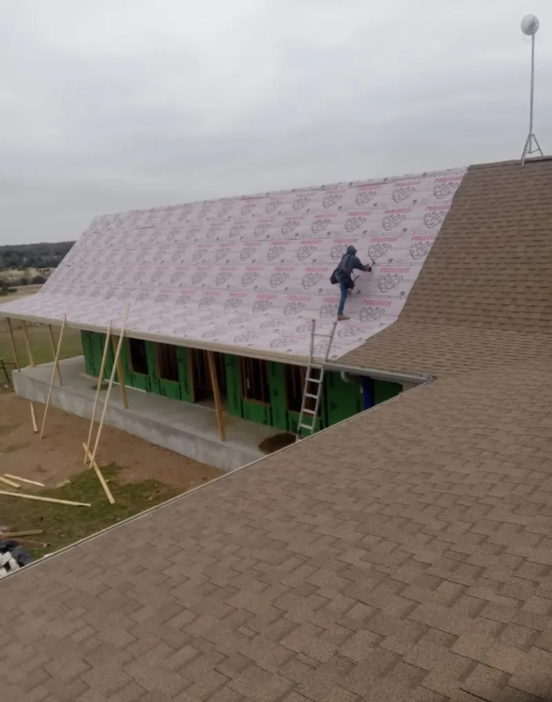 Worker preparing underlayment for a metal roof installation in Kihei